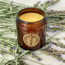 Load image into Gallery viewer, jar of mama sunshine salve over lavender sprigs to display to the loca herbs and botanicals used in the apothecary studion in traverse city