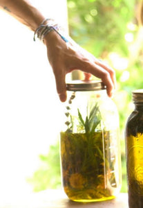 jar of oils and botanicals for mineralizing hair body oil used in treatments at wellness spa poppyandsomeday